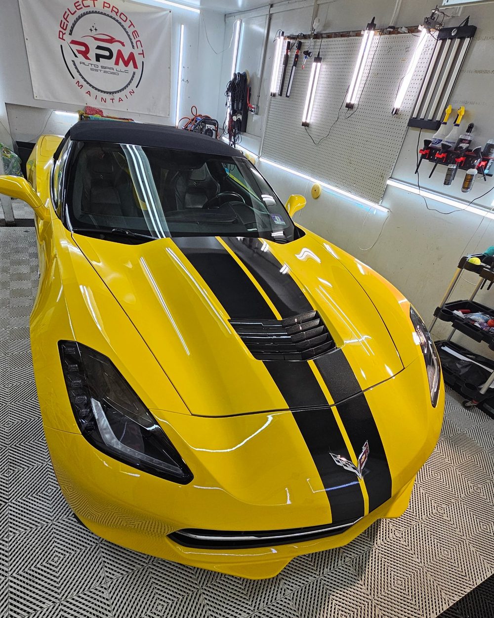 Yellow Corvette convertible with black racing stripes